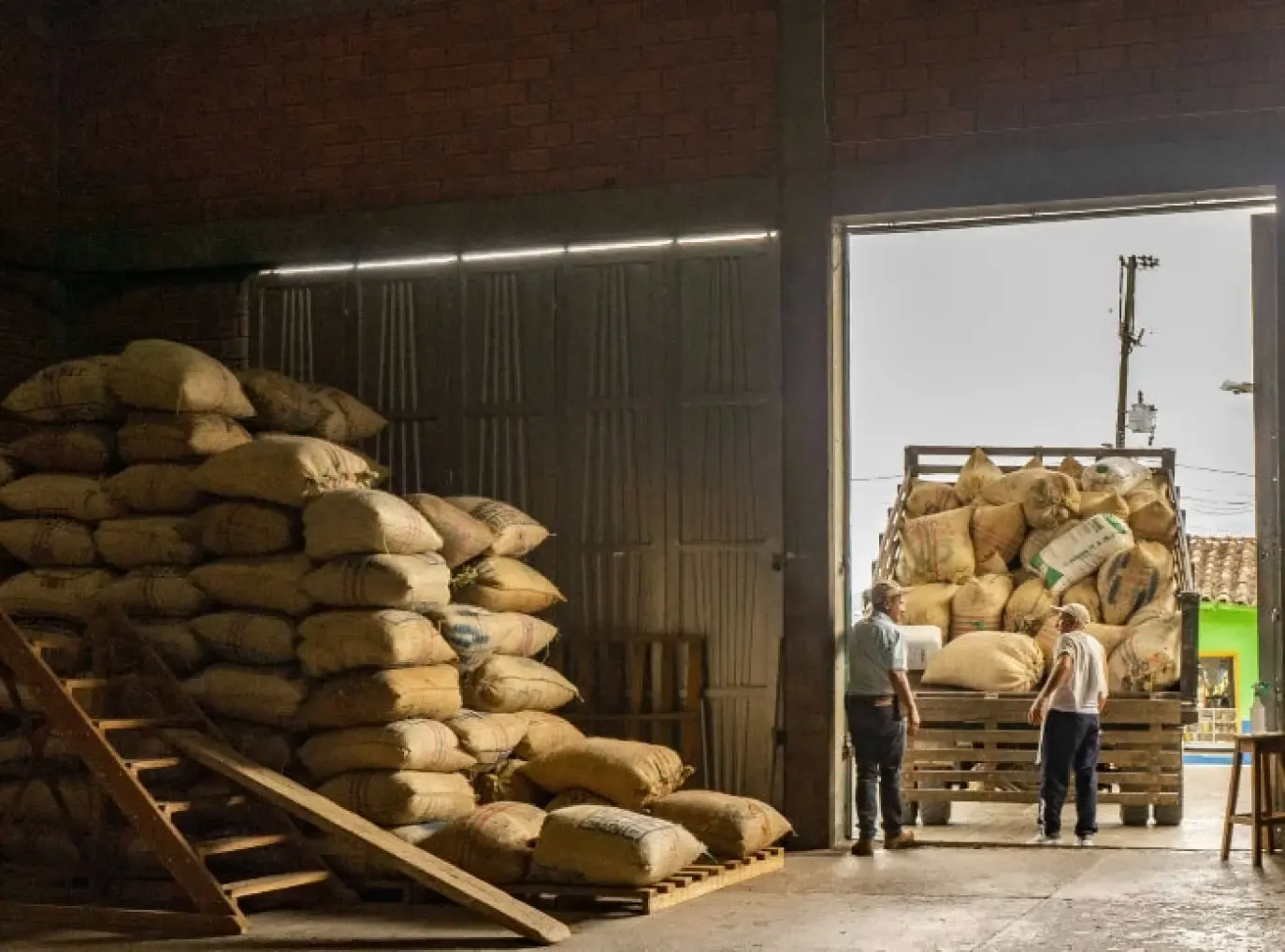 Sacks of coffee being loaded at a warehouse